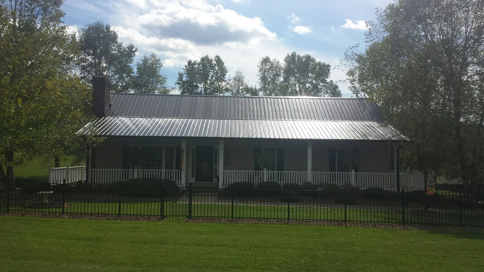 Gray metal roof on a brick ranch with a full width front porch — Gutter Guard Installation work by our crew in Port Gamble