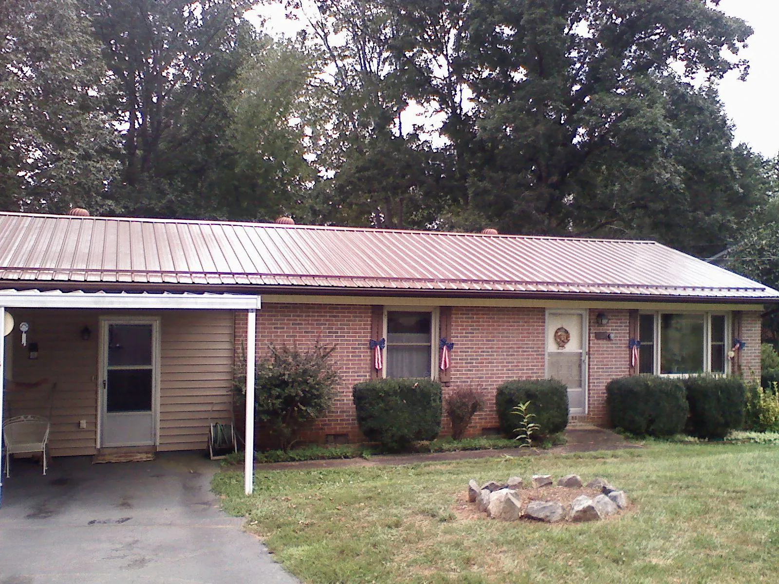 Bronze metal roof and carport on a brick ranch home — Roof Repair work by our crew in Port Gamble